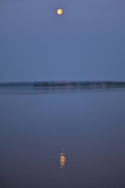 Ay, akşamları nehir suyuna yansıyor. dikey