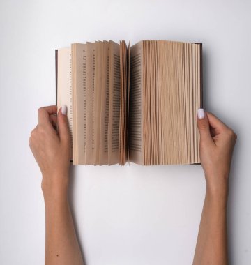 Bir kadının elinde açılmış bir kitap.