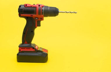 Sarı arka planda matkap ucu olan modern kablosuz tornavida.