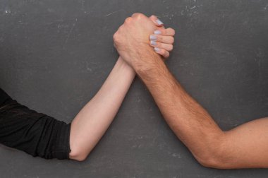 Bir erkek ve bir kadın bilek güreşinde yarışıyorlar..