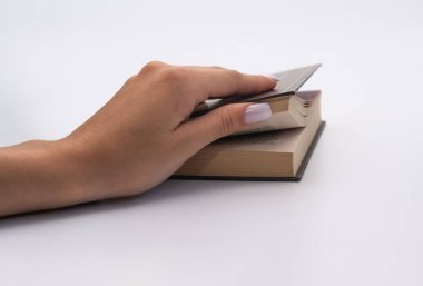 Beyaz arka plan üzerine kadın el kitabı, yolculuğun başlangıcını sembolize ediyor. Kitap, okuma ve entelektüel büyümenin önemini vurgulayarak, yeni fikirlere ve yaratıcılığa açılan kapıyı temsil ediyor..