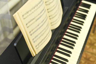 Yüksek teknolojili elektronik piyano üzerine müzik kitabı, öğrenme ve kompozisyonu vurguluyor. Müzik kitabı öğrenmek ve yeni melodiler yaratmak için anahtar bir kaynaktır.