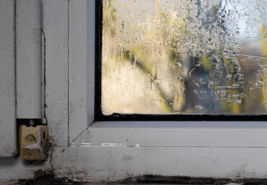 Plastik bir pencerenin ıslak camında nem.