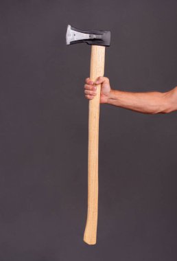 Odun kesmek için baltayı tutan bir adam. dikey