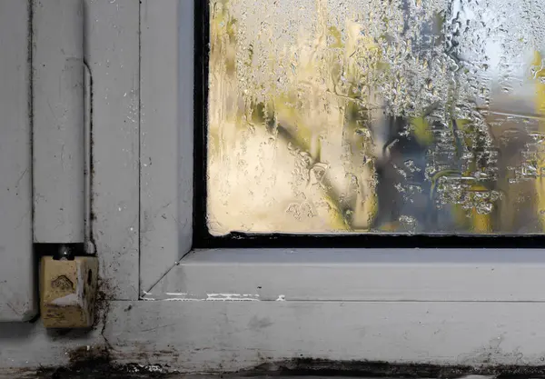 Plastik bir pencerenin ıslak camında nem.