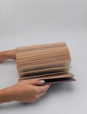 Öğrenme ve kişisel gelişimi temsil eden dikey fotoğraf tutma kitabı. Kitap bilgeliğin ve yaratıcılığın kaynağıdır, eğitimin değerini ve kendini geliştirmenin önemini vurgular.