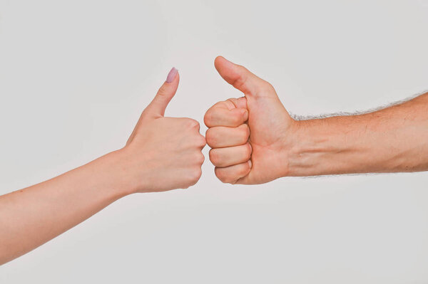 Male and female hands show thumbs up, on a white background