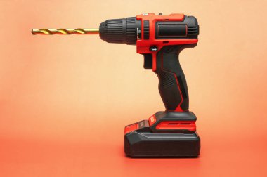 Kırmızı zemin üzerinde koni matkabı olan elektrikli tornavida.. 