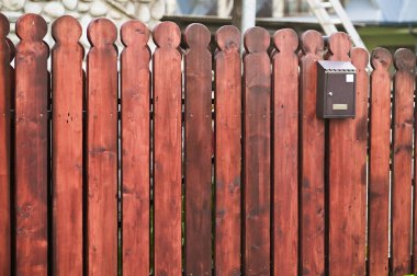 Tahta bir çitte bir posta kutusu asılı.