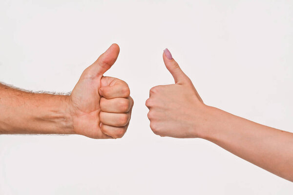 A man's and a woman's hand shows a thumb up gesture. isolated on a white background