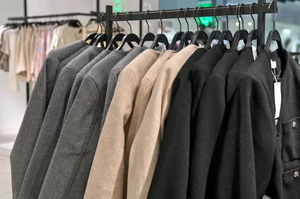 Modern giyim mağazasında şık ceketler asılıydı. Perakende mağazalarında sergilenen klasik resmi kıyafetler, metal raflarda gösterişli takım elbiseler. Giyim mağazasında satılık şık ceketler.