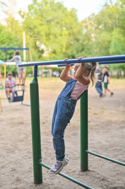Kız direğin ucunda asılı duruyor. dikey