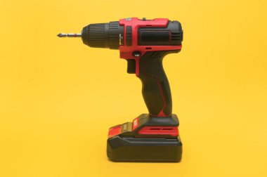 Profesyonel kablosuz tornavida, parlak sarı arka planda izole edilmiş. Chuck ve kauçuk kabzalı endüstriyel tasarım mükemmelliği sergiliyor. Profesyonel kullanım için kablosuz tornavida