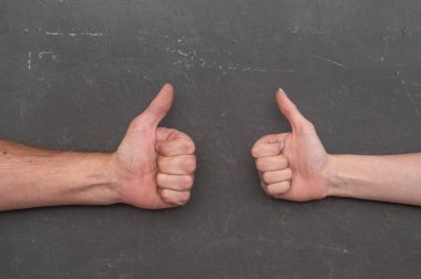 Başparmaklar yukarı veya OK işaretleri insan bağlantısını görselleştiriyor. Sözsüz jestler niyet ve onayı ifade eder. Onay ve desteği ifade ediyor. Tamam ve gri arkaplan üzerindeki jestler kavramını parmakla