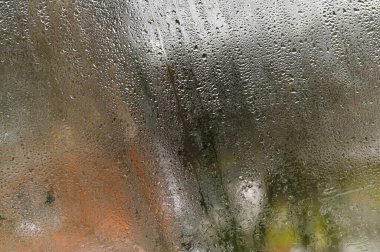 Damlalar ıslak cam üzerinde karmaşık desenler oluşturur, her damla dış görünüşü soyut şekillere dönüştürür. Sis camları, odadaki yüksek nem nedeniyle camda buğulanma. 