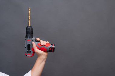 Kablosuz matkap, uzun süre el altında tutulan matkap, elektrikli alet izole edilmiş nötr arka plan, profesyonel ekipman. Uzatılmış matkap ucu ile kablosuz matkap, modern güç aracı izole