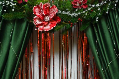 Kumaş bileşimi üzerine yapay çiçekler. Kırmızı çiçekli çiçek aranjmanı, renkli kurdeleler. Uyumlu, şenlikli bir atmosfer. Kırmızı çiçeklerin yer aldığı dekoratif bir düzenek. soyut arkaplan