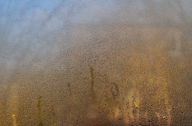 Küçük su damlacıklarıyla kaplı ıslak cam pencere. İçerideki nem, şeffaf yüzeyde doğal desen oluşturur. soyut bulanık arkaplan, ıslak cam dokusu 