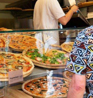 İtalya 'da bir sokak yemekhanesinde farklı türde pizza satılıyor.