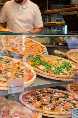 İtalya 'da bir sokak yemekhanesinde farklı türde pizza satılıyor.