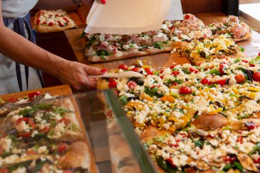 İtalya 'da bir sokak yemekhanesinde farklı türde pizza satılıyor.