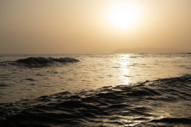 Deniz. Akdeniz sahillerinde güzel altın bir gün batımı. Hava sisi içinde alışılmadık bir ışık var.