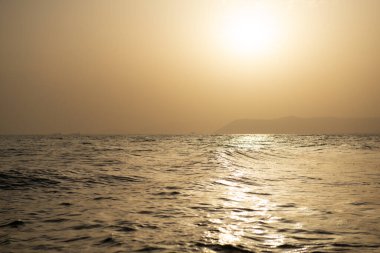 Deniz. Akdeniz sahillerinde güzel altın bir gün batımı. Hava sisi içinde alışılmadık bir ışık var.