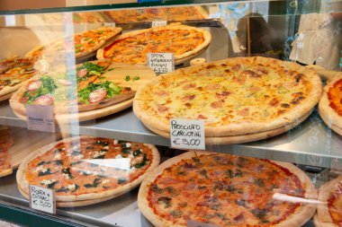 İtalya 'da bir sokak yemekhanesinde farklı türde pizza satılıyor.
