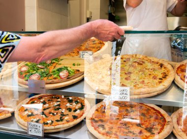 İtalya 'da bir sokak yemekhanesinde farklı türde pizza satılıyor.