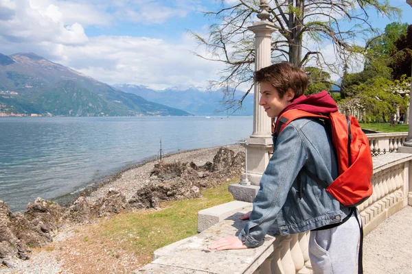 Yakışıklı delikanlı parkta yürüyor, manzarası harika Como ve Alps dağları, baharda doğada güzellik, İtalya, Lombardy