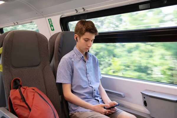 Handsome Cheerful Teen Boy Riding Train Using Smartphone — Stock Photo, Image