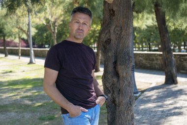 Parkta poz veren orta yaşlı bir adam, açık hava resmi. Yakışıklı, olgun bir adam. Açık hava erkek portresi. 