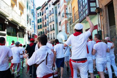 Şarap ile yıkanan insanlar geleneksel beyaz abd kırmızı elbiseyle San Fermin festivalini Pamplona, Navarra, İspanya 'da kırmızı kravatla kutluyorlar.