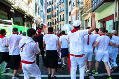 Şarap ile yıkanan insanlar geleneksel beyaz abd kırmızı elbiseyle San Fermin festivalini Pamplona, Navarra, İspanya 'da kırmızı kravatla kutluyorlar.