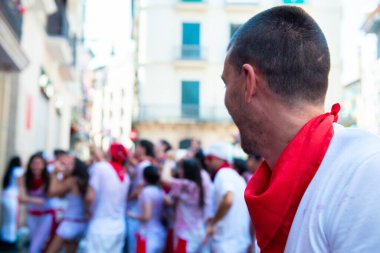 Şarap ile yıkanan insanlar geleneksel beyaz abd kırmızı elbiseyle San Fermin festivalini Pamplona, Navarra, İspanya 'da kırmızı kravatla kutluyorlar.