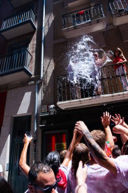 Şarap ile yıkanan insanlar geleneksel beyaz abd kırmızı elbiseyle San Fermin festivalini Pamplona, Navarra, İspanya 'da kırmızı kravatla kutluyorlar.