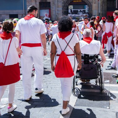 İnsanlar San Fermin festivalini Pamplona, Navarra, İspanya 'da kırmızı kravatlı geleneksel beyaz abd kırmızı elbiseyle kutluyorlar.