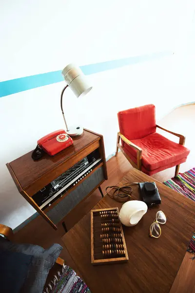 Cosy vintage room with retro radio turntable, telephone, standart lamp, armchair as well and abacus, camera, glasses. Interior of 20th century, nostalgia