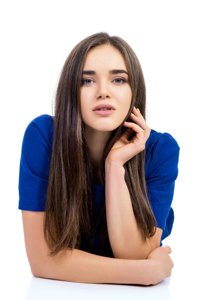 Очаровательная молодая женщина, держась за руки аккуратно к лицу, позируя на белом фоне