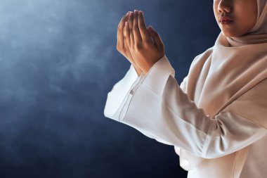 Genç Asyalı Müslüman genç kız karanlık arka planda dua ediyor, Kurban Bayramı Mübarek konsepti