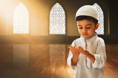 Cami kemerinde dua eden Asyalı Müslüman çocuğun portresi, Kurban Bayramı Mübarek konsepti.