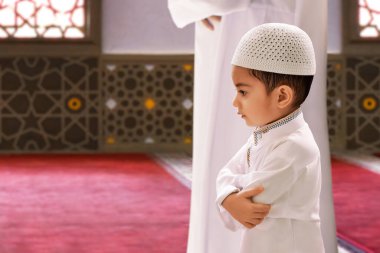 Endonezyalı Müslüman baba ve masum oğul camide birlikte dua ediyorlar, Kurban Bayramı Mübarek kavramı.