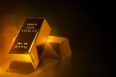 Koyu duman arka planında parlak altın külçeler