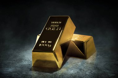 Koyu arkaplanda parlak altın külçeler yığını