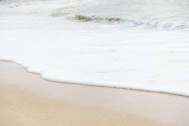 Yumuşak dalgalar kumlu kıyıya çarpar, dingin ve sakin bir atmosfer yaratır. Yumuşak köpük, altın kumla çok güzel zıtlaşır. Rahatlamaya ve sükunete davetiye çıkarır..