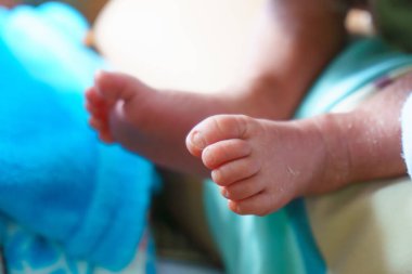 Yumuşak yüzeyde dinlenen, narin ayak parmakları ve pürüzsüz derisi olan minik bir bebek ayağı. resim masumiyeti ve çocukluğun sıcaklığını yakalar.