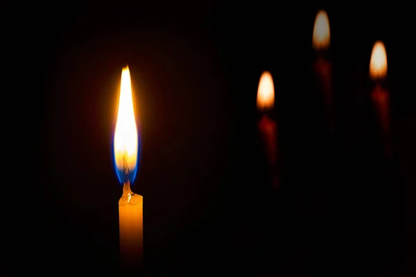 一支在黑色背景上燃着的蜡烛 — 图库照片