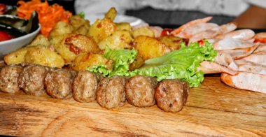 Tahta tezgahta patates ve marullu sosis.