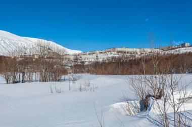 Eriyen kar, parlak bahar güneşi, buz saçakları, açık yollar, Kirovsk Murmansk bölgesi Hibiny