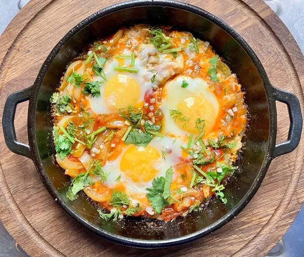 stock image Thai style fried egg with vegetable in black pan on wooden table